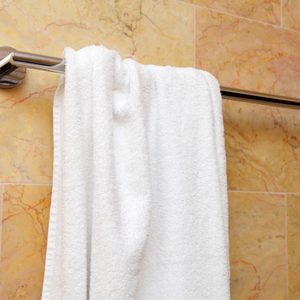 white bath towel hanging on a towel rod in the bathroom