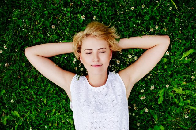 Portrait of a young woman lying on the grass