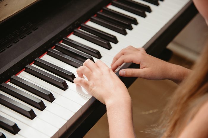 Close up hands playing keyboard.