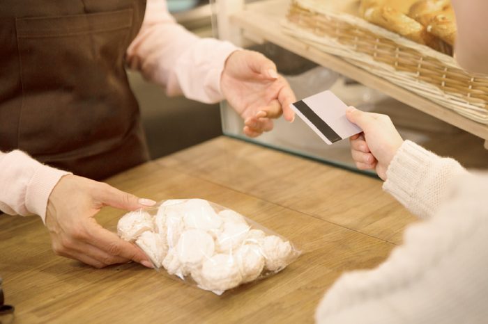 Cropepd shot of a little girl paying with a credit card for a pack of cookies at the store groceries food dessert eating payment consumtions customer consumerism banking children kids lifestyle.