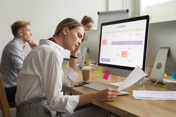 Frustrated tired businesswoman reading document with bad news, corporate employee stressed by mistake in paperwork, troubled with problem, upset about dismissal notice or feeling headache at work