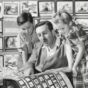 December 27, 1946 - Walt Disney shows 2 young actors, Bobby Driscoll (left), and Luana Patten (right) the storyboards for his new production, 