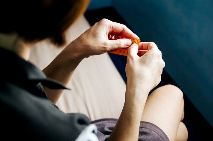 Woman hand holding contraceptive pill ready to eat.