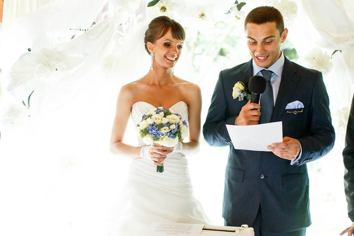 smiling groom and bride on the background white curtains