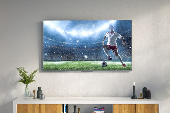 3D illustration of a living room led tv on white wall showing soccer game moment .