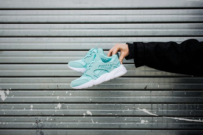 sneakers urban background, sneakers in hand