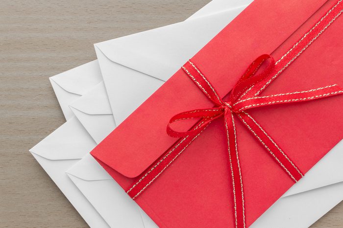 pile of envelopes with red envelope on top