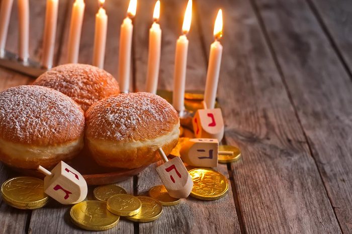 Jewish holiday hannukah symbols - menorah, doughnuts, chockolate coins and wooden dreidels. Copy space background.