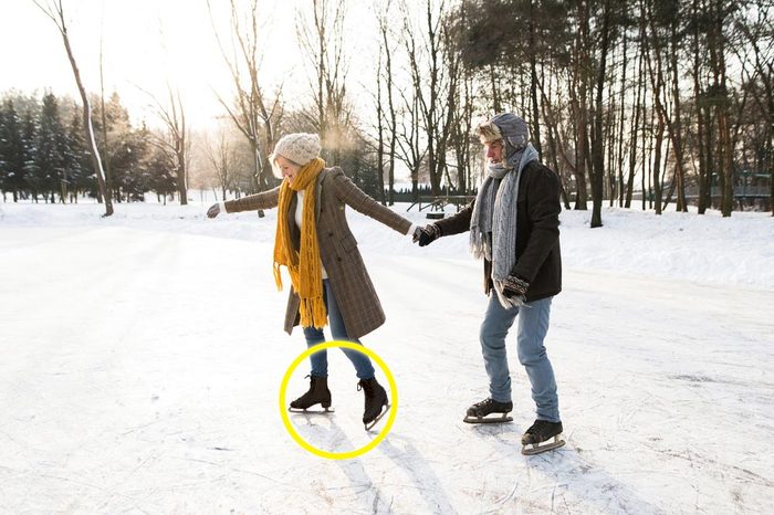 Senior couple in sunny winter nature ice skating.