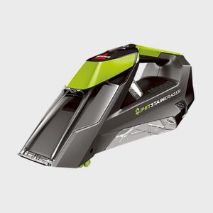 A handheld carpet cleaner features a black and green design, poised for cleaning. Text reads 