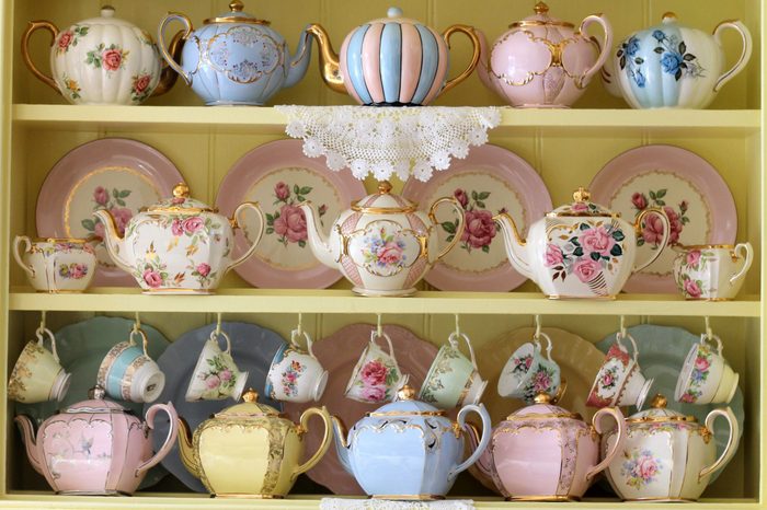 Vintage yellow kitchen dresser display of teacups tea cup teapots floral and pastel - high tea party