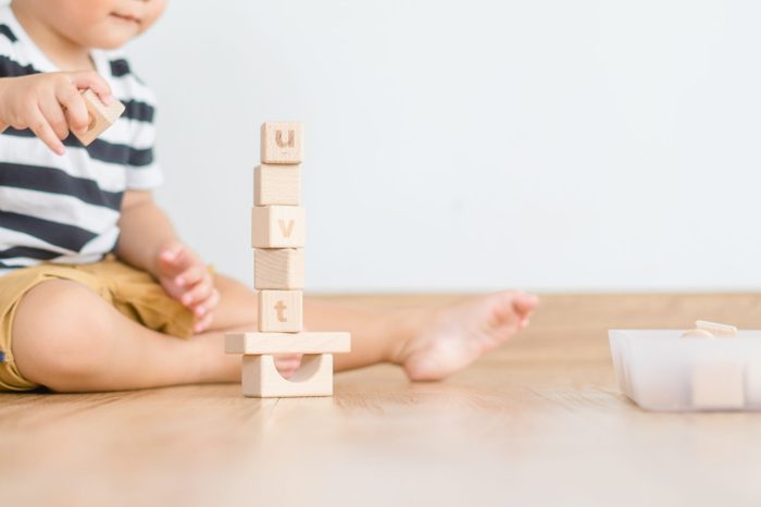 2 years baby boy.Little child boy playing with lots of wooden toys block with mother.Kids play with educational toys at home.Day care and Kindergarten school.child development concept.