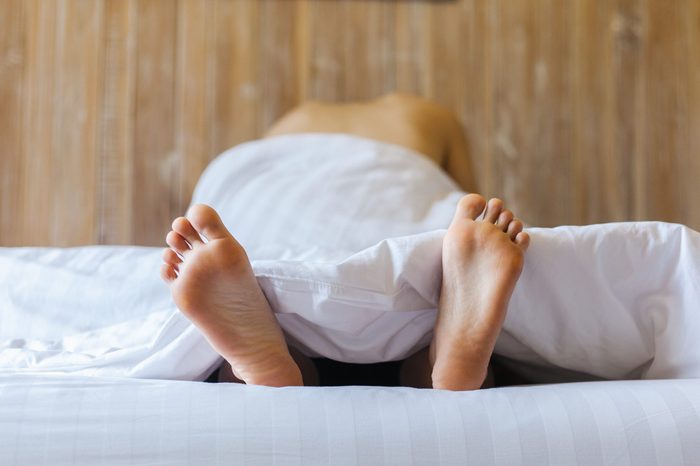 Couple on a bed, Loving couple having sex under white sheets in the bedroom.