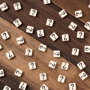 Tiles display question marks, scattered across a wooden surface.