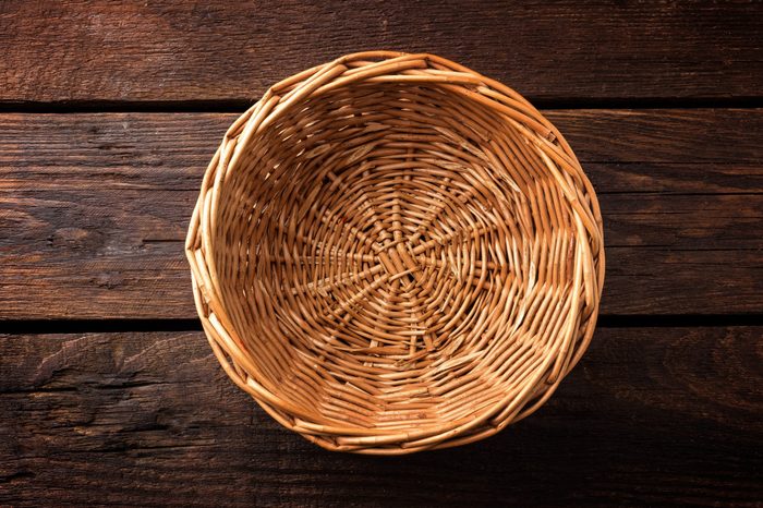 Empty wicker basket on a wooden background, top view