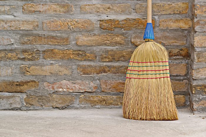 Household Used Broom For Floor Dust Cleaning Leaning on Brick Wall