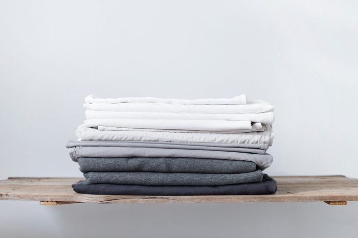 linen textile in stacked pile. sheet and cover. different shades white grey pastel color cloth. background. copy spase