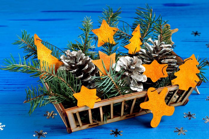 Child making decorations of orange peel for Christmas. Children's art project. DIY concept. Step by step photo instruction. Step 7. Final result