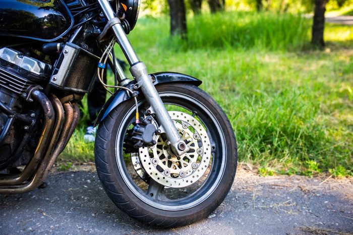 The front wheel of a motorcycle. Close up brakes and spokes
