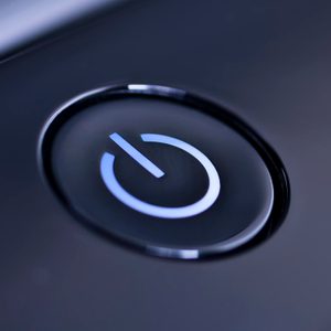 Power button glowing blue, embedded on a sleek, dark device surface.