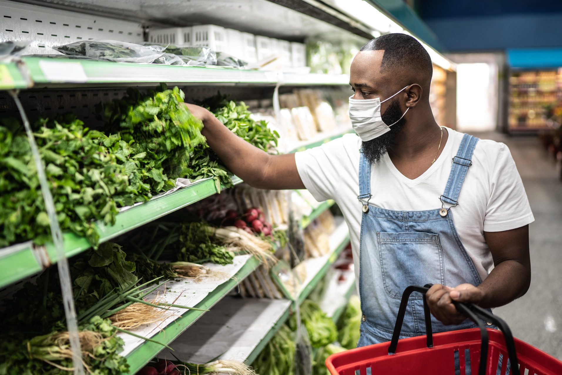 Man with face mask walking and shopping in supermarket