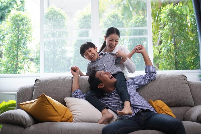 Family playing together father giving his son piggyback ride happiness time together at home