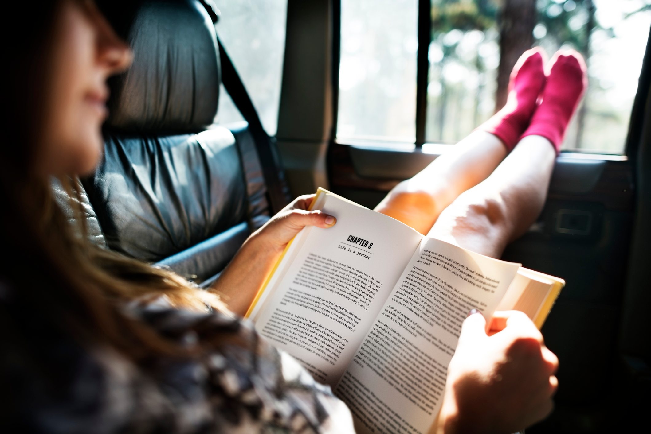 Girl Reading Book Inside Car Concept