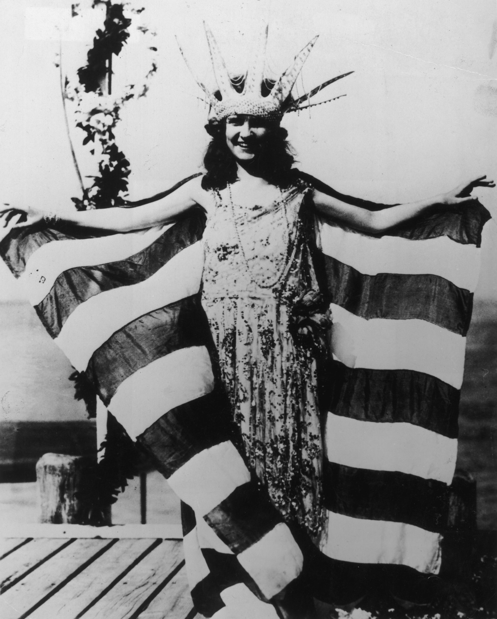 First Miss America standing in front of flag