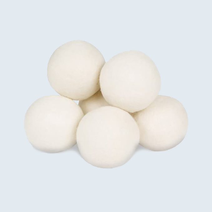 White wool balls stacked together against a light blue background.