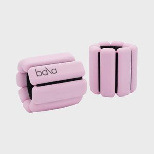 Two pink ankle weights sit upright against a plain background, with 