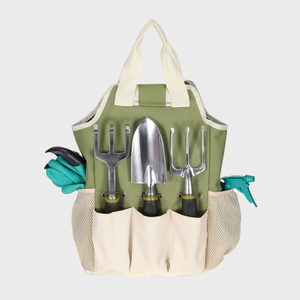 Garden tools in a green tote bag, organized with a trowel, fork, and gloves, against a plain background.