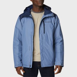 Jacket-wearing person stands, displaying a light blue Columbia jacket with a hood, over a beige shirt, in a neutral studio setting.