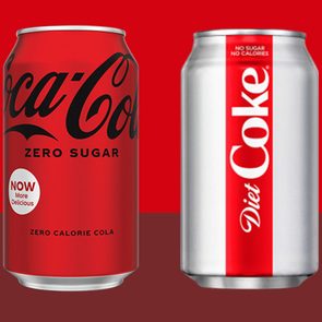 Two soda cans stand side by side. The left is red (