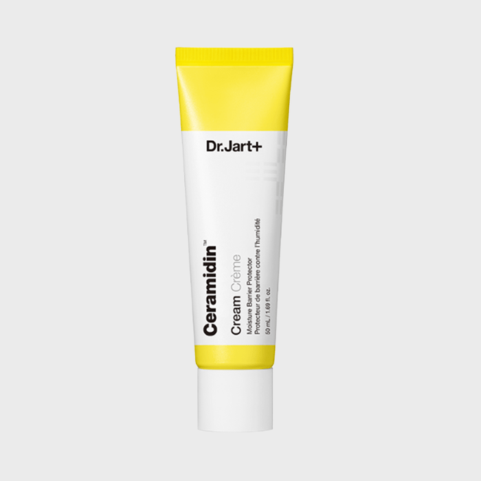 Tube stands upright, displaying skincare text, against a plain background.
