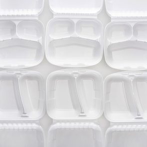 White, open clamshell food containers are arranged neatly in a grid pattern against a plain background.