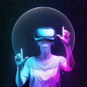Person wears virtual reality headset, interacts with holographic interface; vibrant pink and blue lighting creates a futuristic atmosphere.