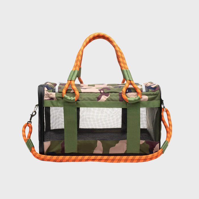 Camo-patterned, mesh-sided pet carrier with orange handles and strap; displayed against a plain background.