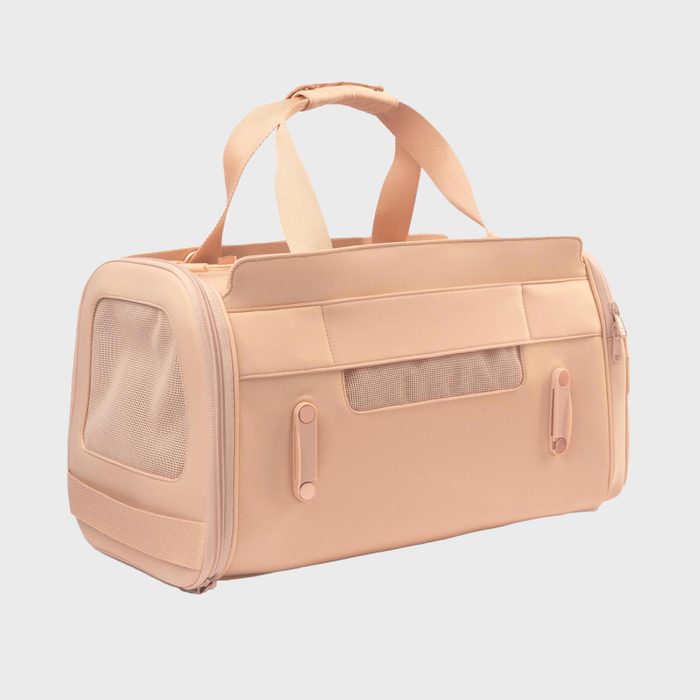 Beige pet carrier bag, featuring mesh panels, sits upright against a plain white background.