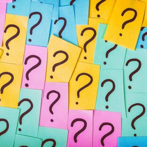 Question marks decorate colorful sticky notes overlapping randomly, creating a vibrant and curious pattern.