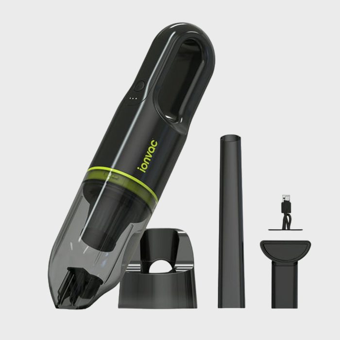 Handheld vacuum displayed with accessories and charging cable on a plain background. Text reads 