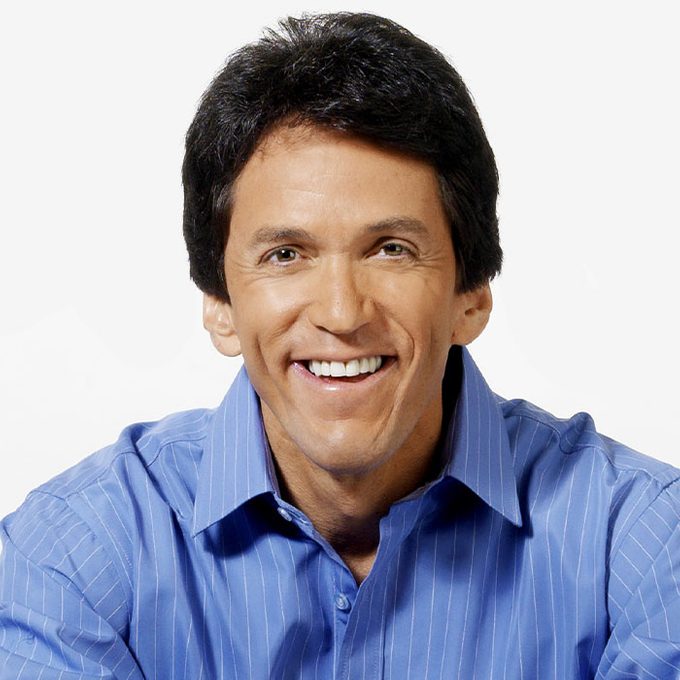 Smiling person wearing a blue shirt against a plain white background.