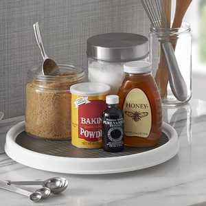 Ingredients sit on a round tray; honey, vanilla extract, baking powder, brown sugar, and flour jars with a spoon, whisk, and wooden spoons nearby.