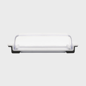 A rectangular butter dish features a clear lid and sits on a flat, white base with small black accents against a plain backdrop.