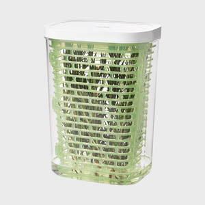 Container holds herbs inside a green grid structure, placed on a light gray background.