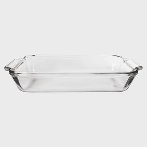Glass baking dish sits empty on a plain, light gray background, featuring rectangular shape with handles on each side.