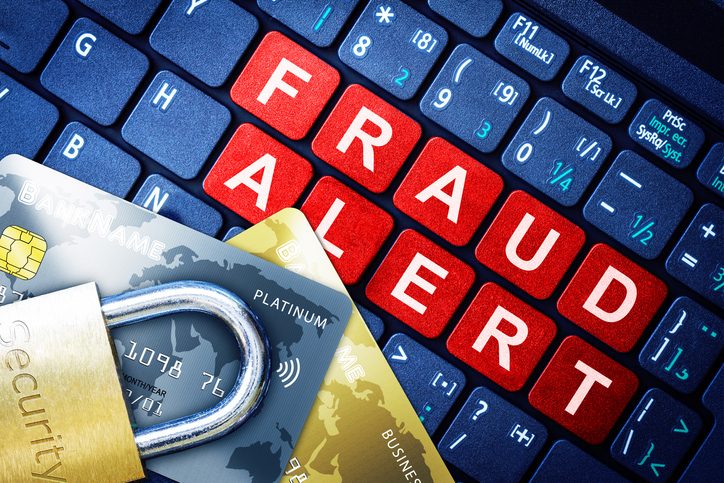 Fraud Alert Concept With Security Lock and fake credit cards on a computer keyboard