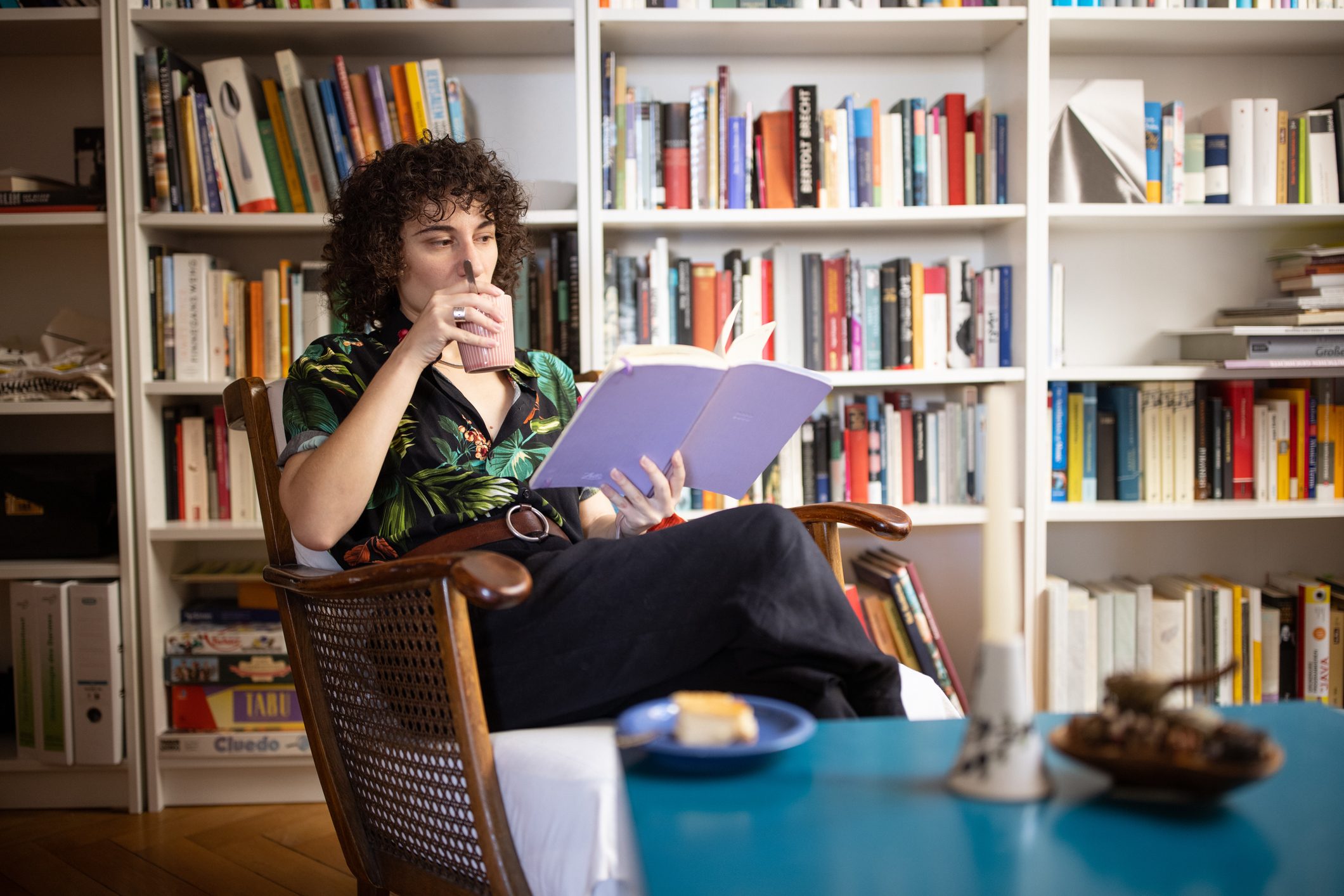 person reading a book and having coffee