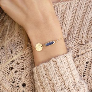 Bracelet rests on wrist, featuring a round gold charm with 