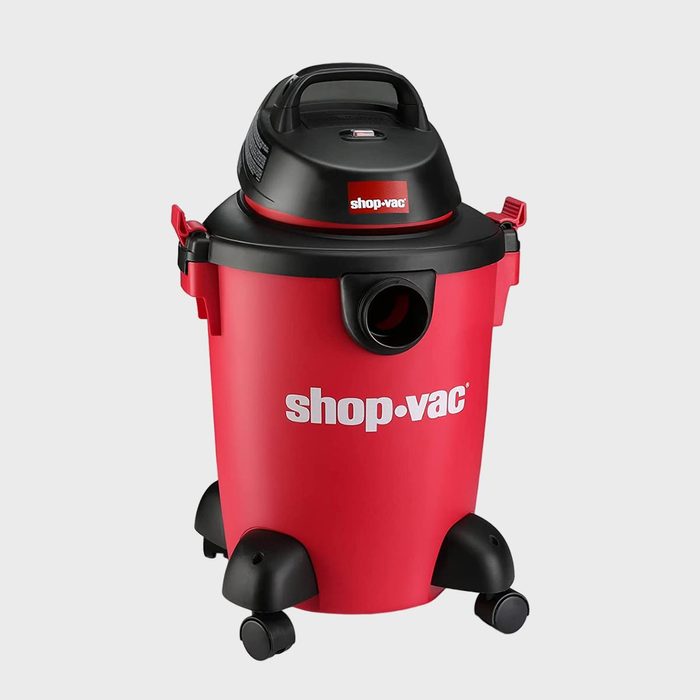 Red vacuum cleaner standing on wheels, labeled 