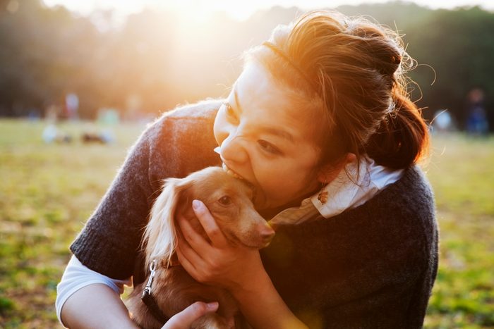 woman and dog playing in the park